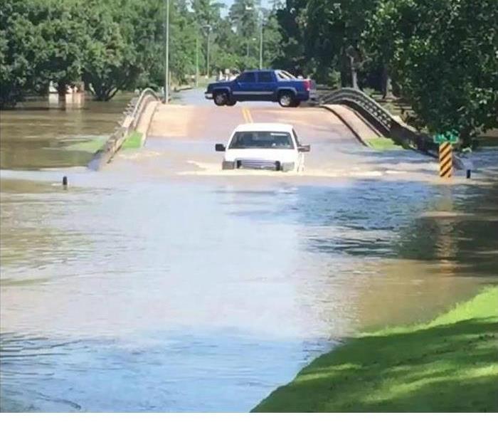 flooded roadway with a vehicle driving through
